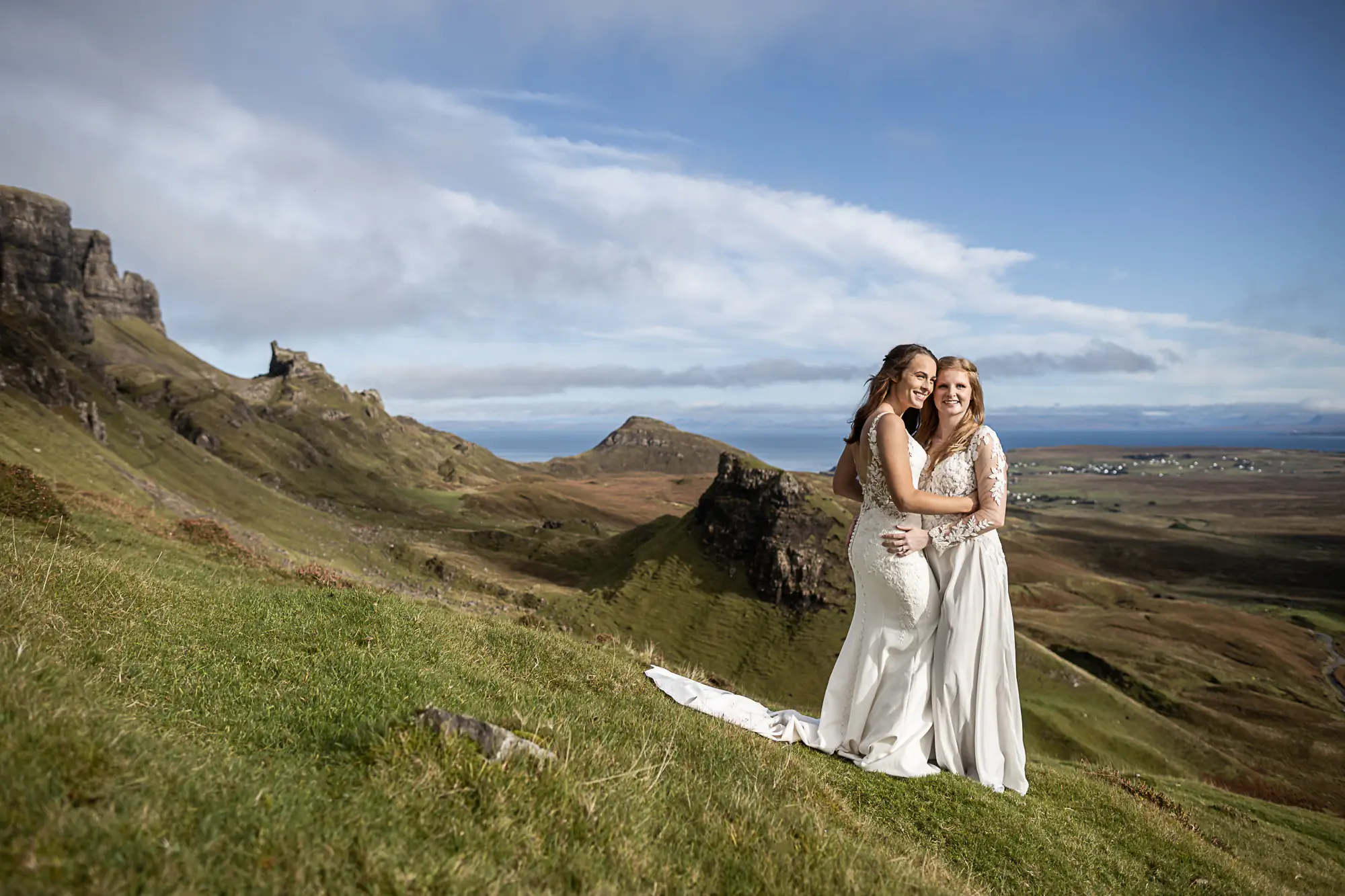 brides cuddle on the side of a mountain