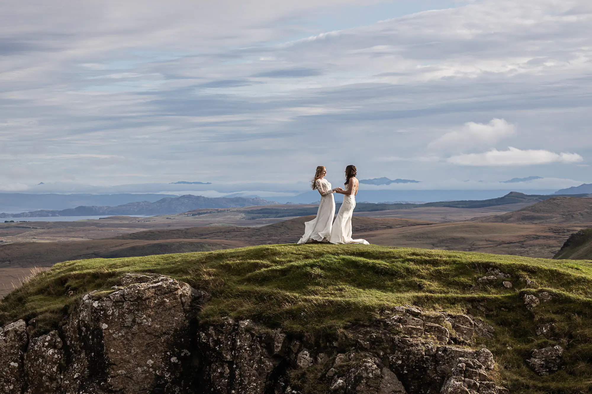 two brides just married embrace on a mountain