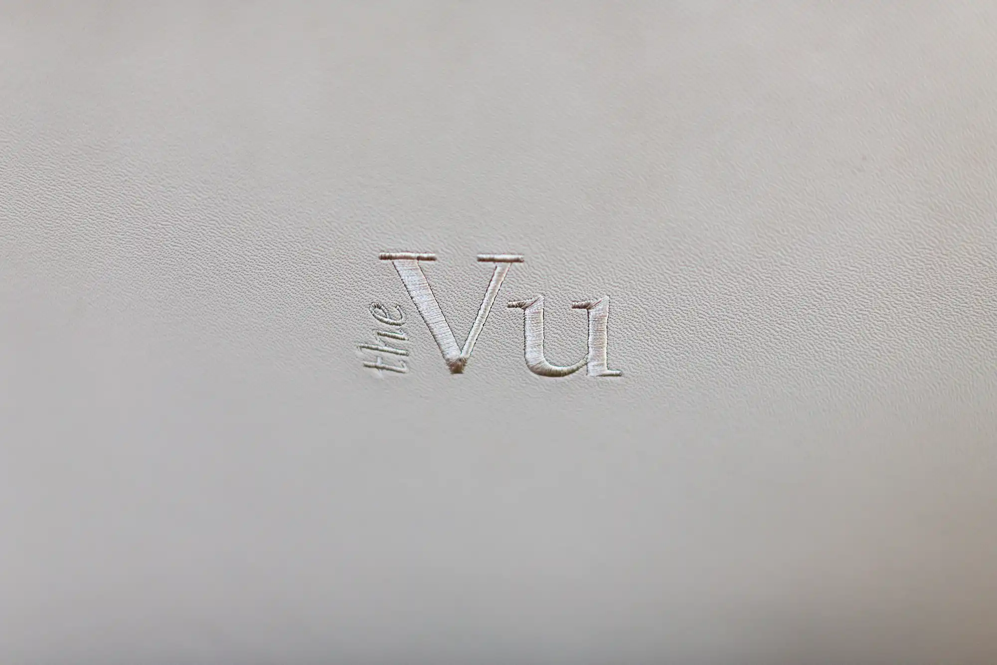 Embossed text "the vu" on a textured white background.