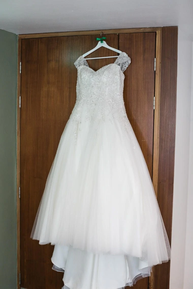 bridal gown hanging from the door of the bridal prep suite