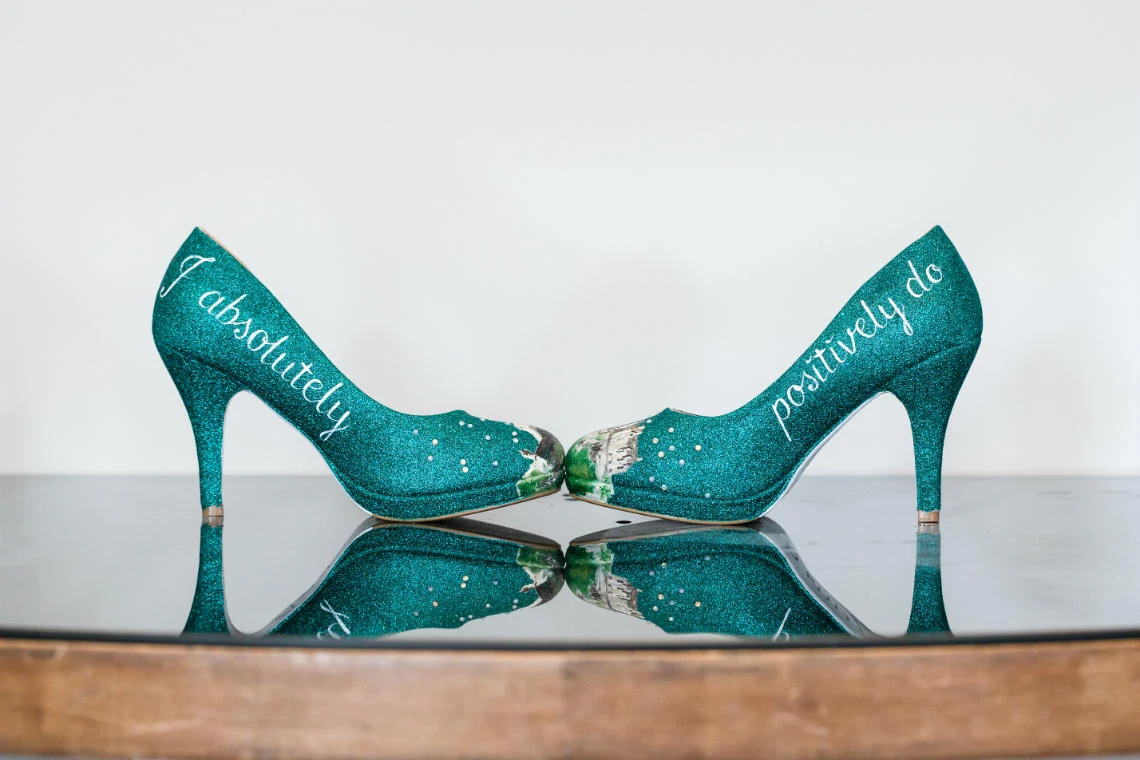 dark green bridal shoes with 'I absolutely positively do' written on the side