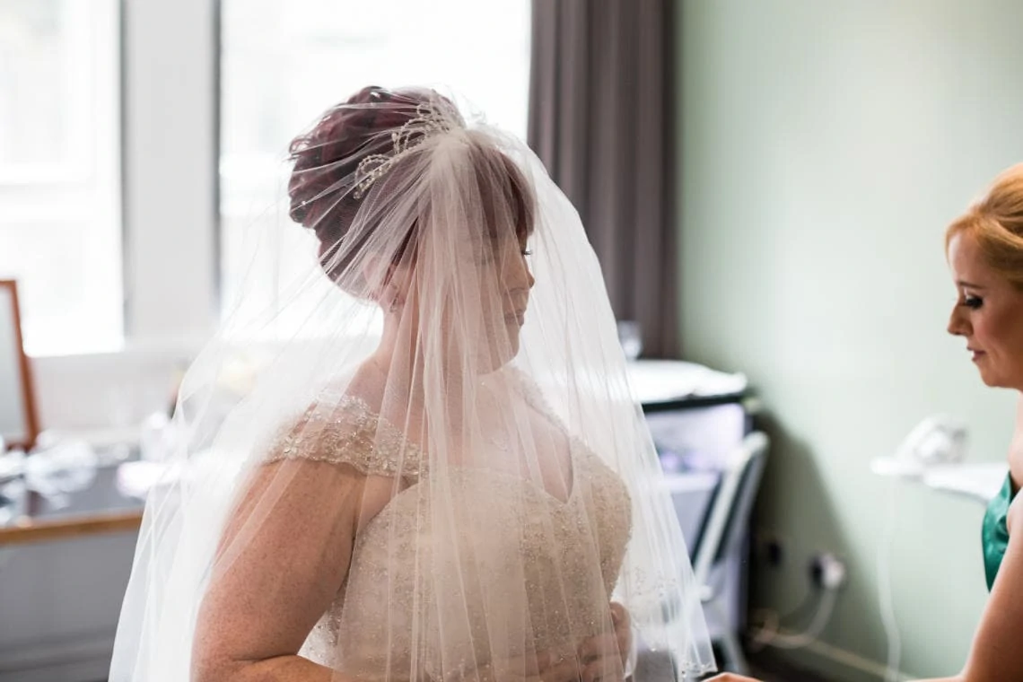 bride tries on her veil before the ceremony
