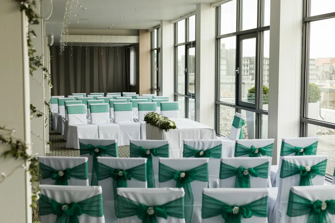 The Heights restaurant seats with white chair covers and dark green tie-back ribbons