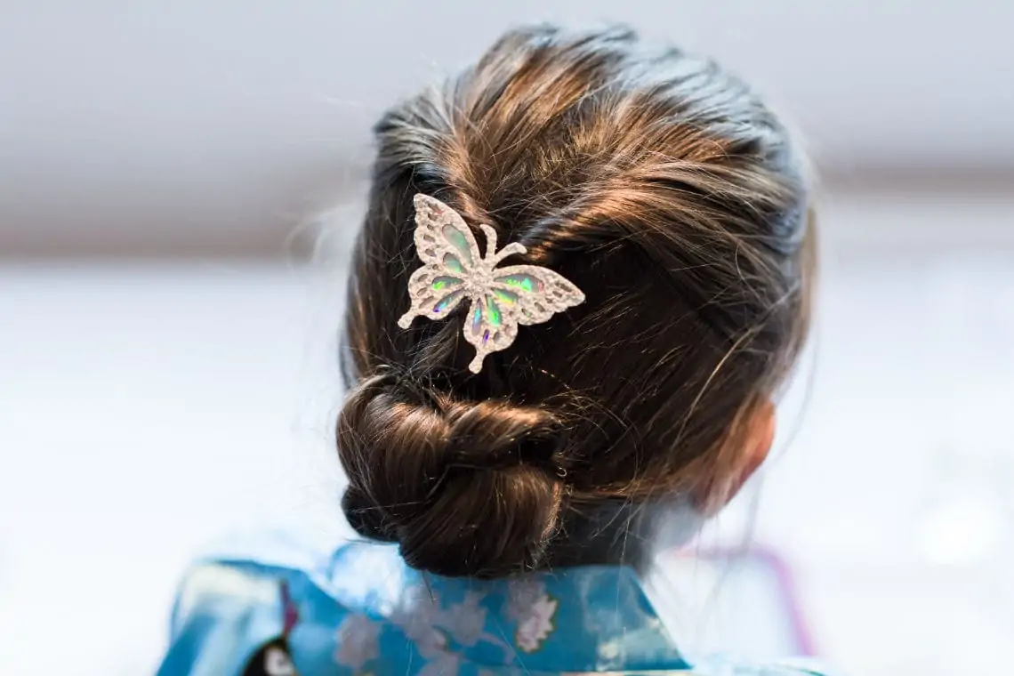 back of head of young girl's hairstyle with butterfly hair clip