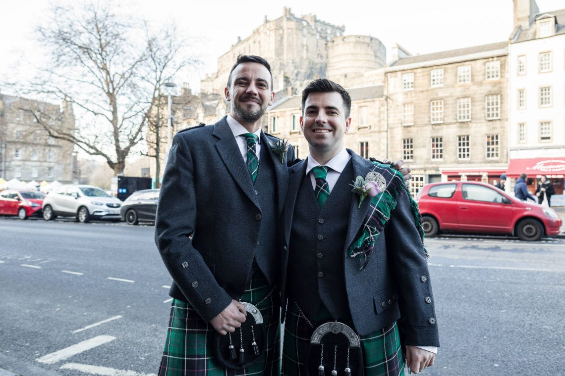 portrait of groom and bestman dressed in full highland wear with Edinburgh Castle in the background
