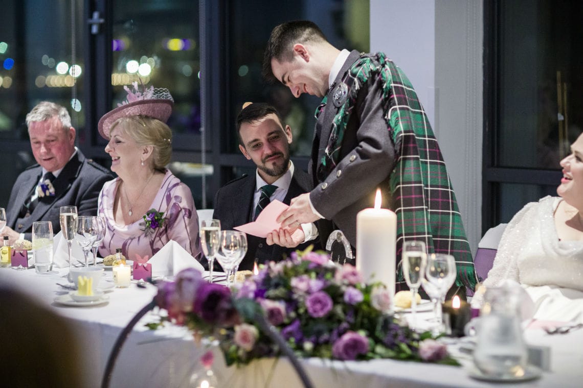 groom shares a joke at the top table