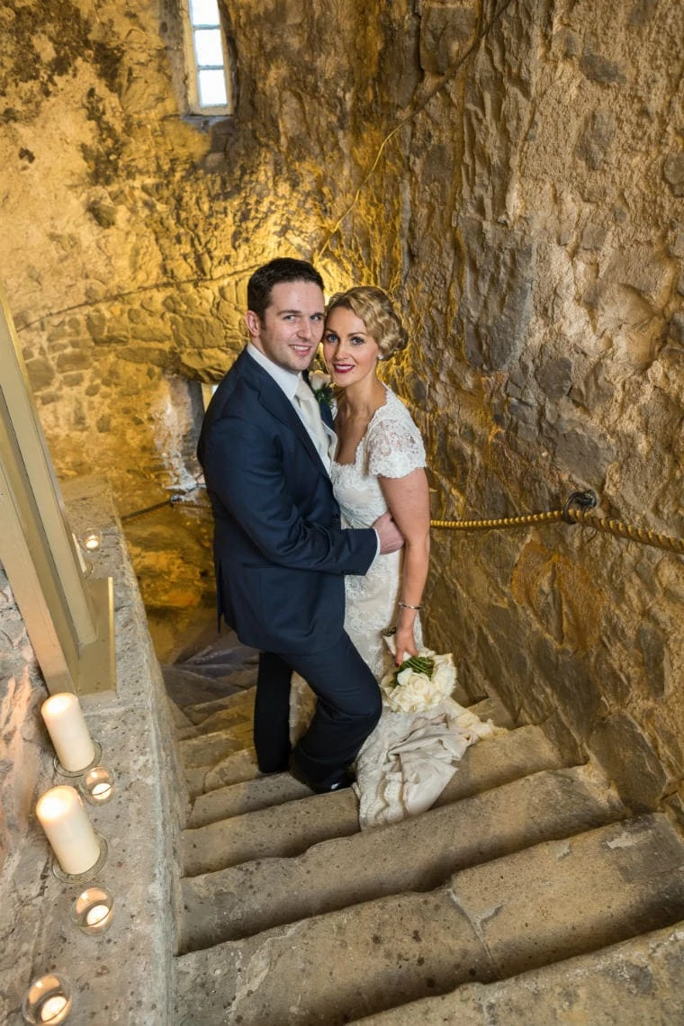 Auld Keep staircase newlyweds embrace looking at camera