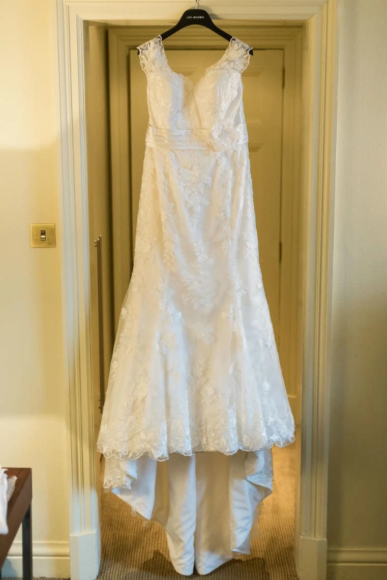 bride's dress hanging from a door frame