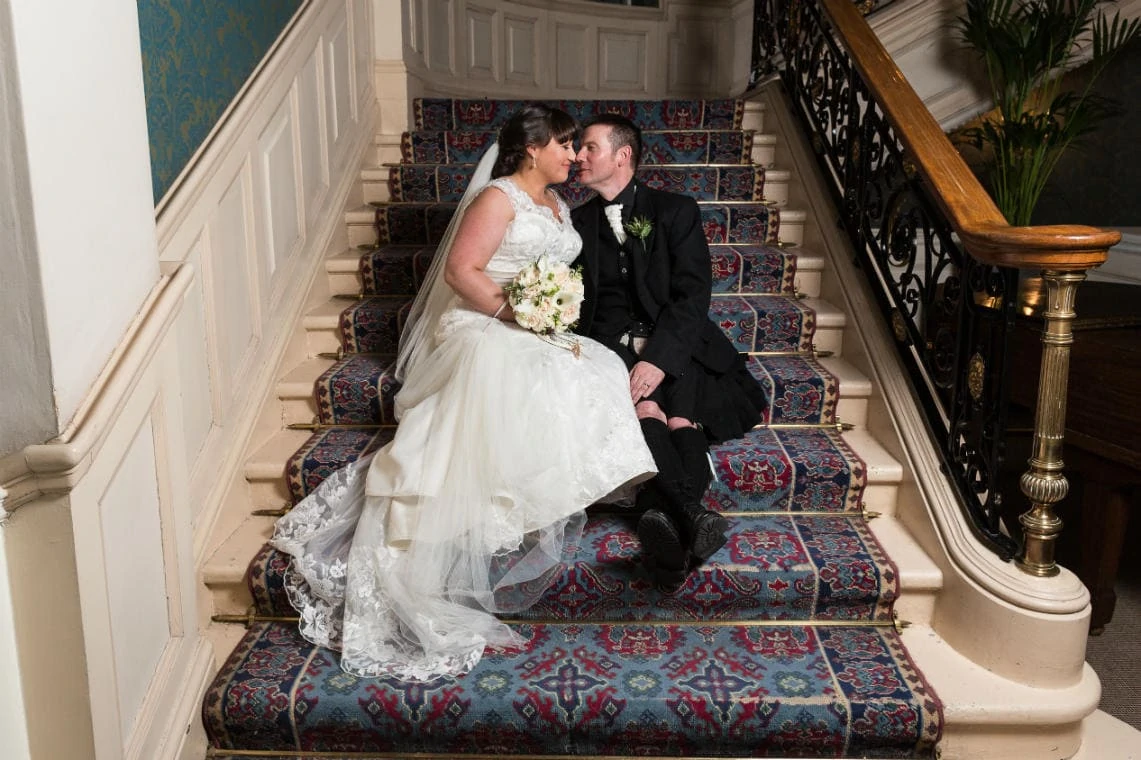 newlyweds sitting on the grand staircase