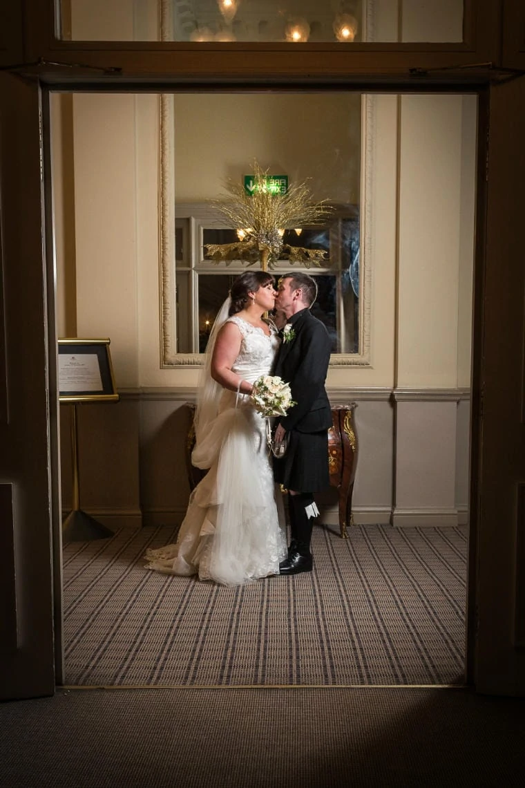 newlyweds kissing in the corridor