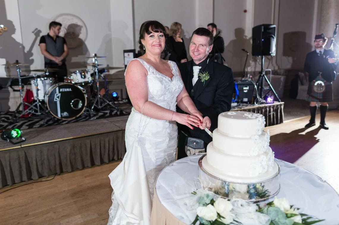 newlyweds cut the cake in the Sir Walter Scott Suite