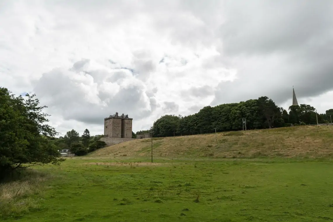 Outside view of Borthwick Castle with fields in the foreground