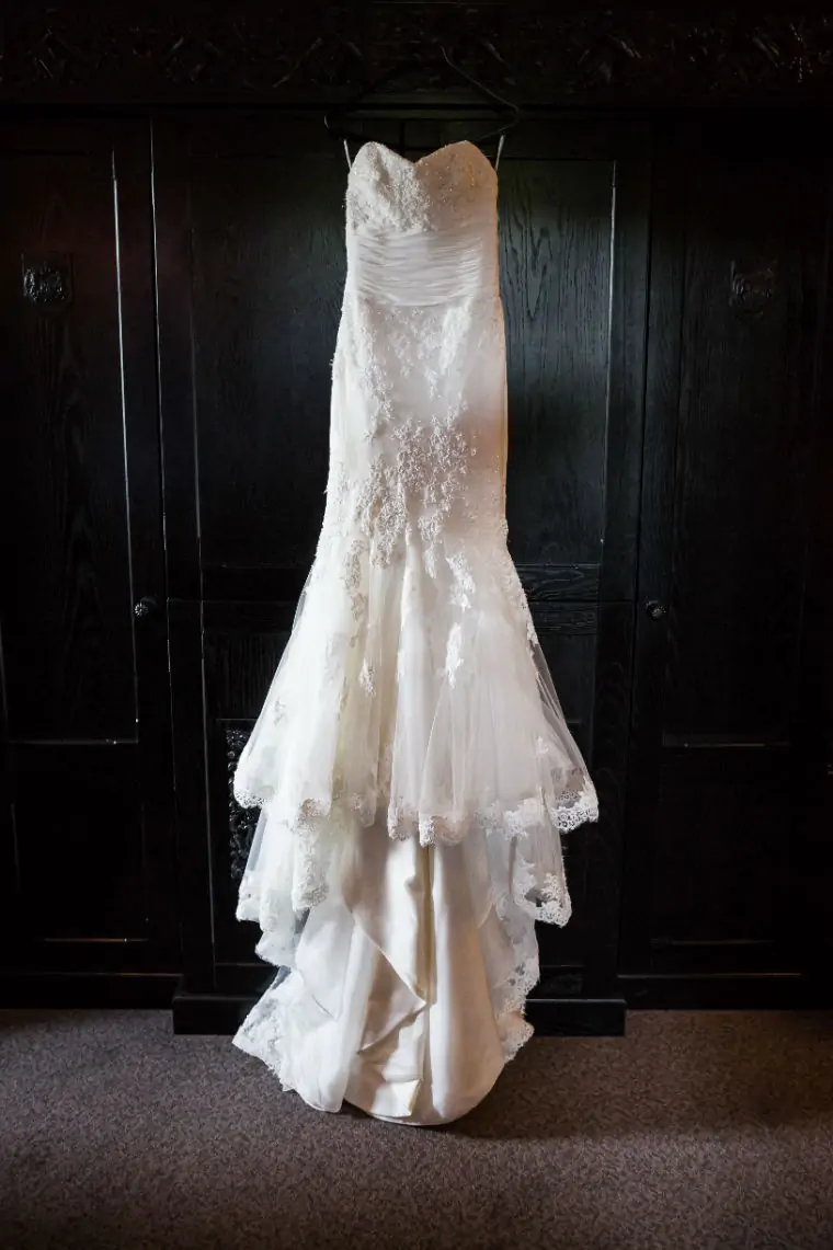 wedding dress hanging up against a wardrobe
