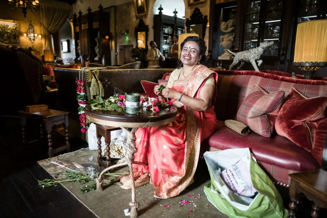 Indian lady sitting on a sofa arranging roses