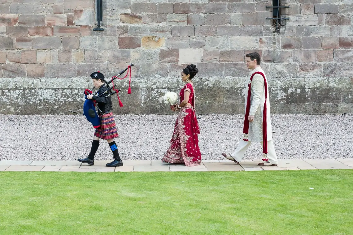 Piper with bride and groom following behind