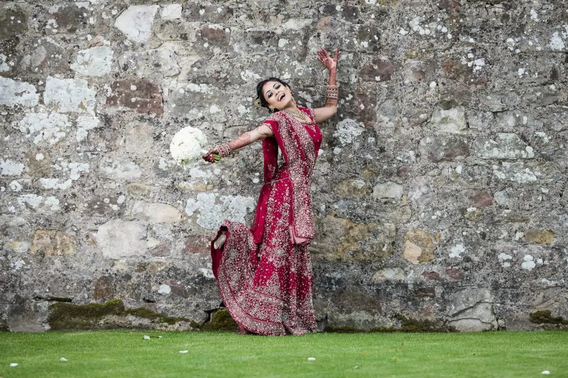 Bride dancing in front of castle wall