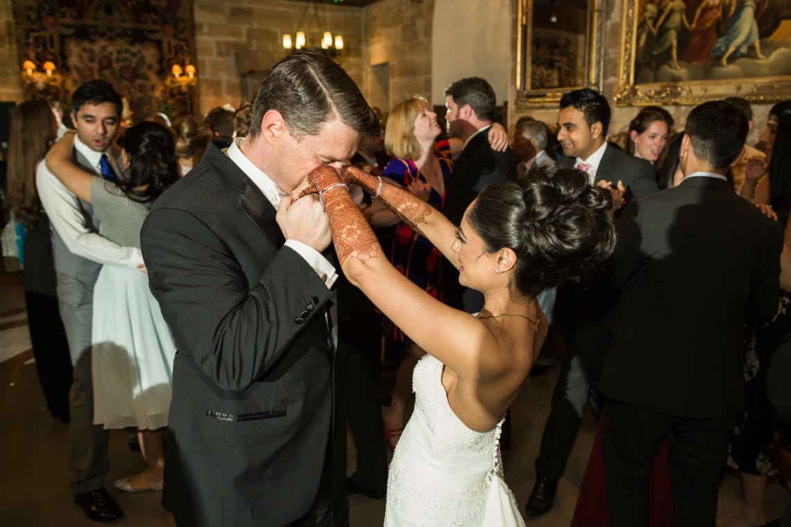 Groom kissing bride's hands