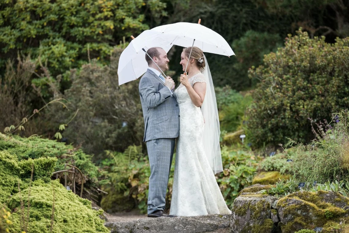 Botanic Gardens newlyweds-in-the-rain-under umbrellas by the waterfall