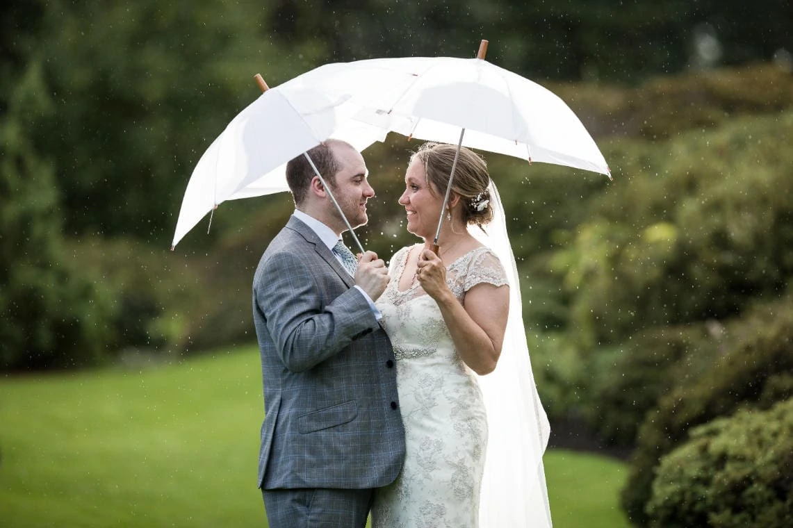 Botanic Gardens newlyweds in the rain under umbrellas