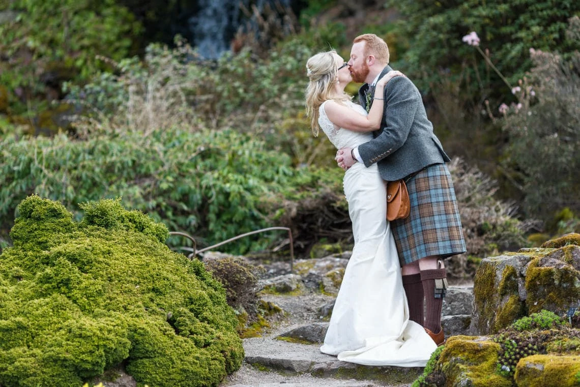 Botanic Gardens newlyweds kissing by the waterfall