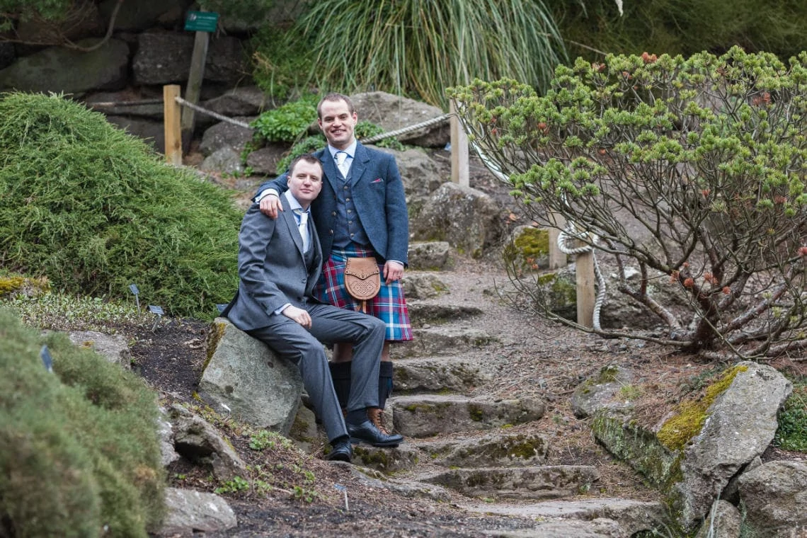 Botanic Gardens same-sex newlyweds embrace in the Rock Garden