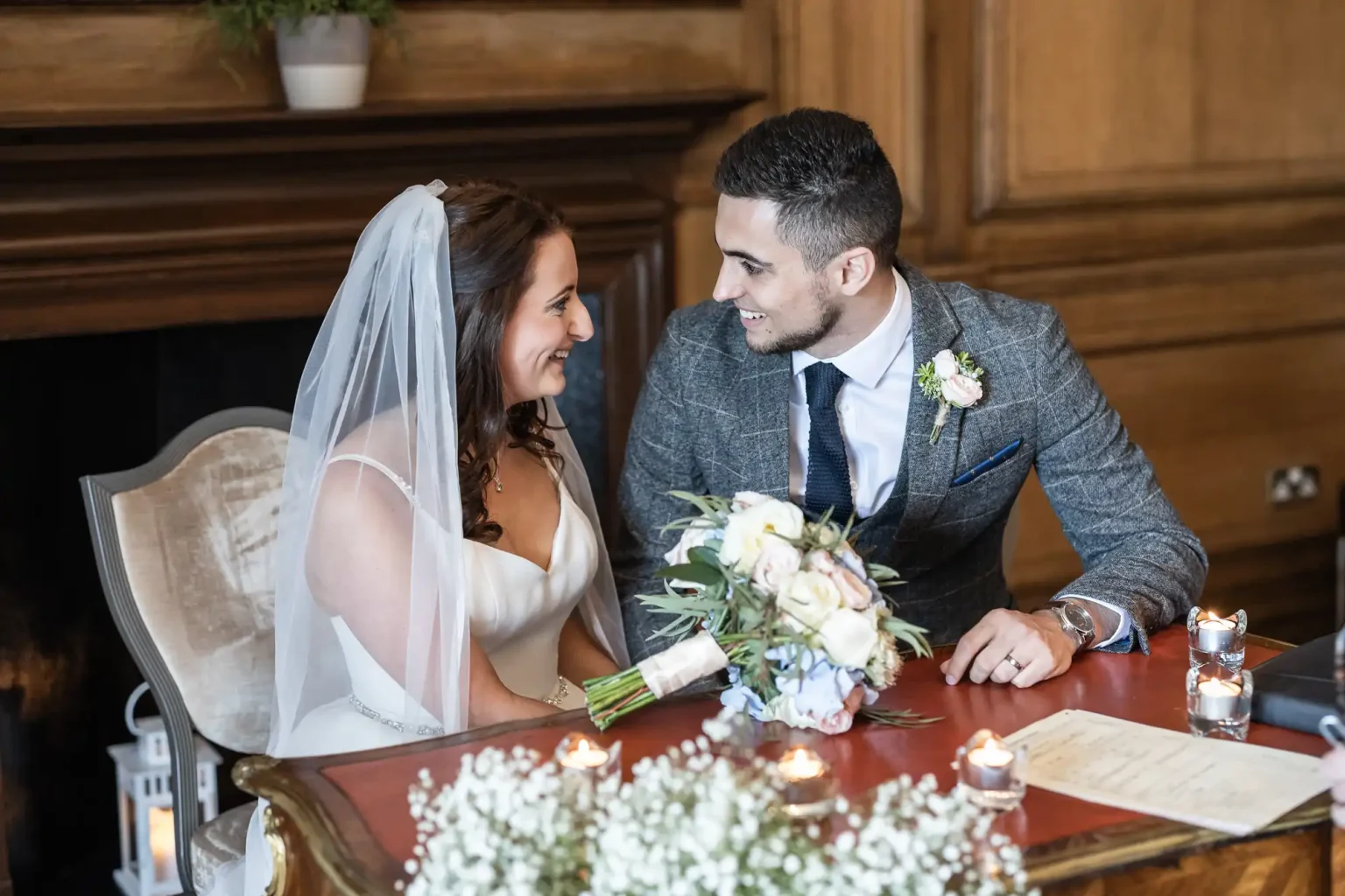 Newlyweds look at each other while signing the marriage schedule