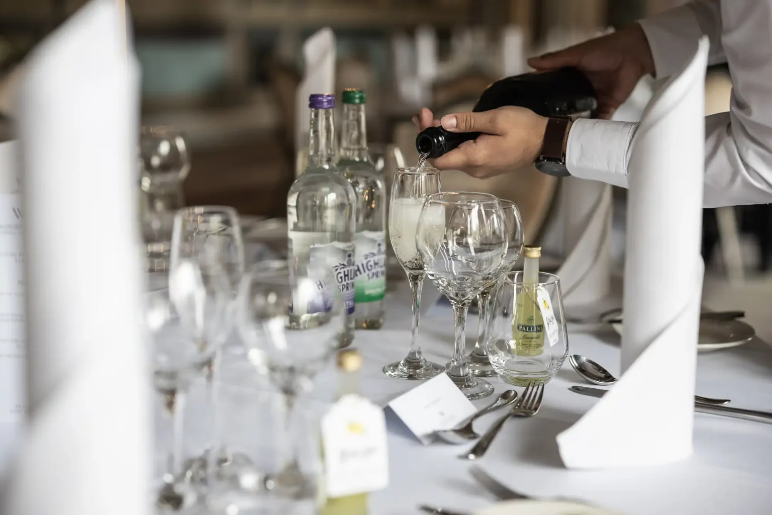 staff pouring champagne into a glass