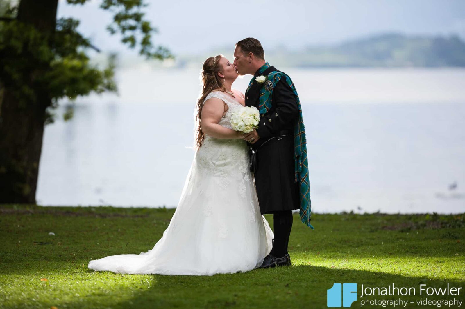 Cameron House Hotel wedding photo of newly-weds on the banks of Loch Lomond