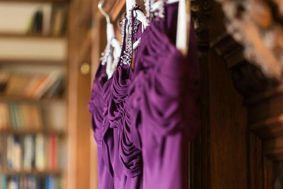 bridesmaid's purples dresses hanging up in The Library