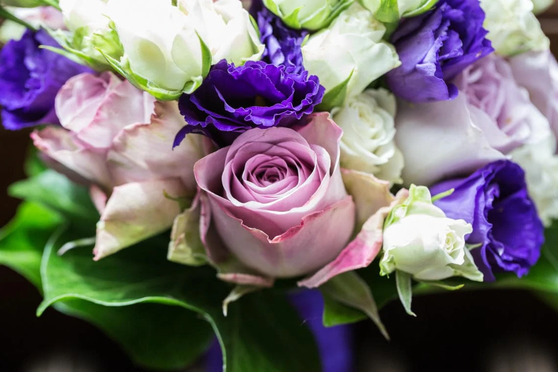 bridesmaid's bouquet white, purple and pink roses with purple ribbon