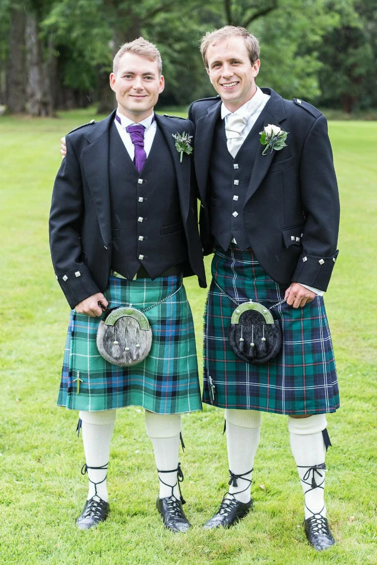 groom and best man wearing highland kilt outfits on the lawn