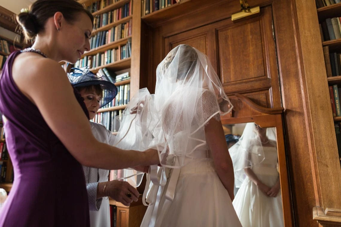 bride's dress being buttoned up in the Library