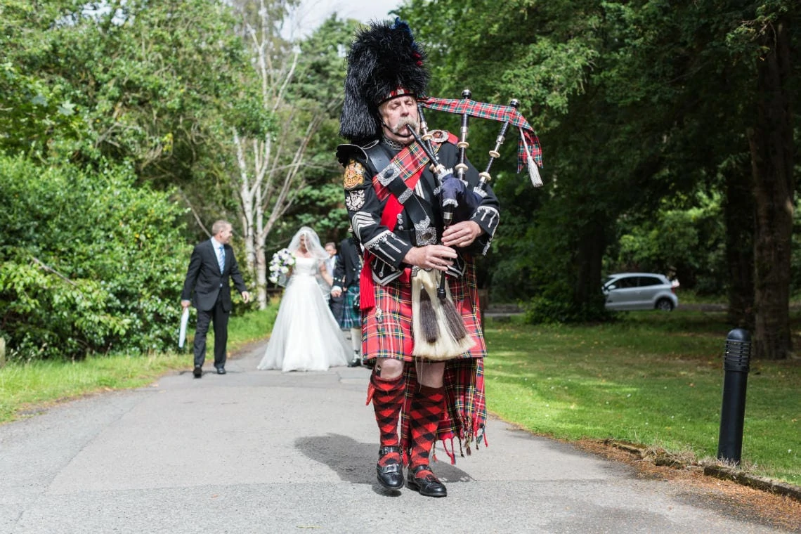 Pipe Major Iain Grant leads the newlyweds to Carberry Tower