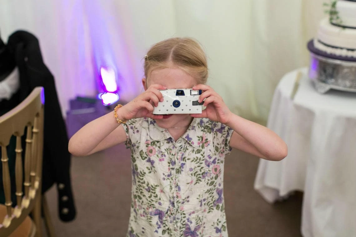 young guest taking a photo with a disposable camera in The Pavilion