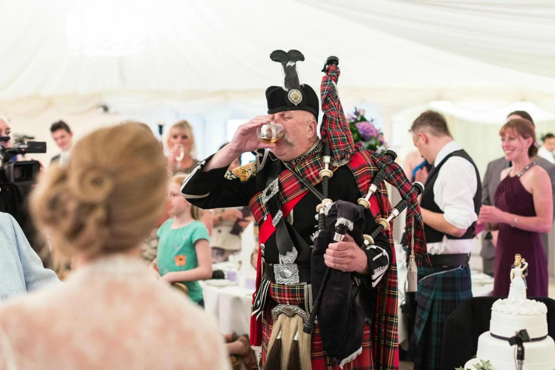 Pipe Major Iain Grant raises a toast to the newlyweds in The Pavilion