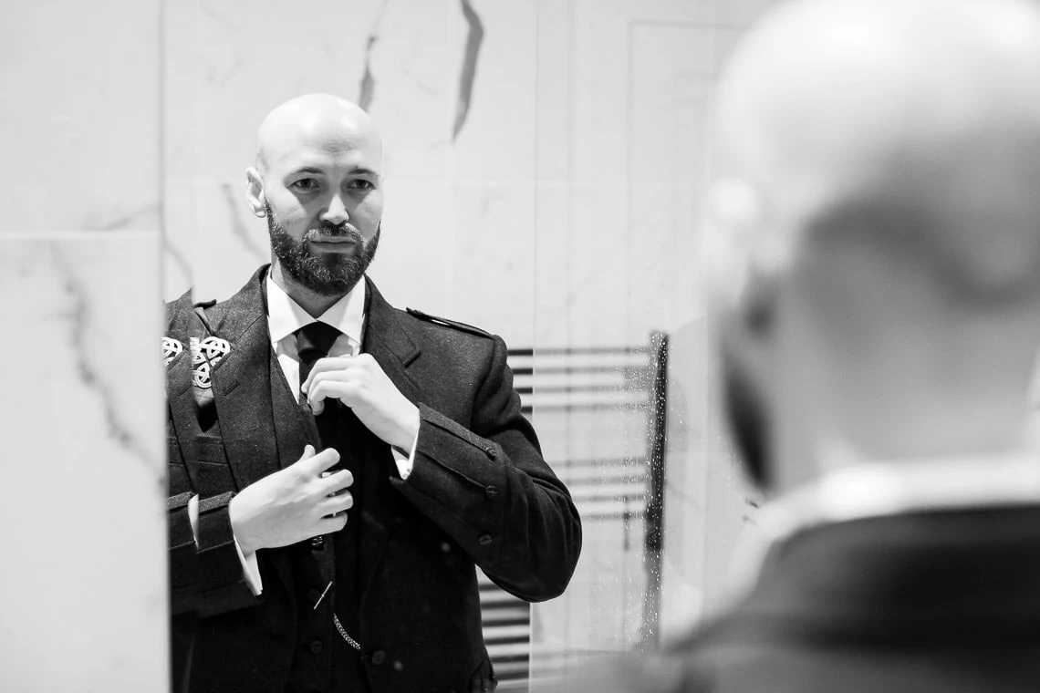 groom pre-ceremony adjusting his tie
