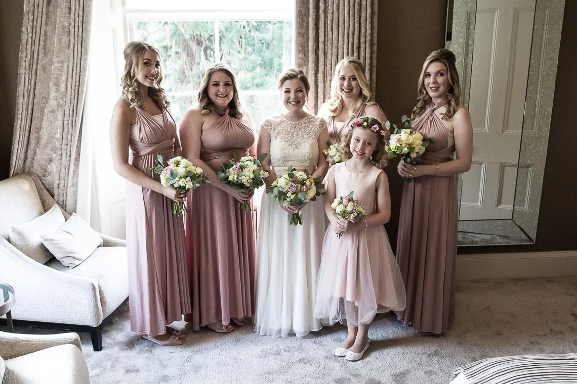 bride, bridesmaids and flower girl pre-ceremony group photo in bedroom