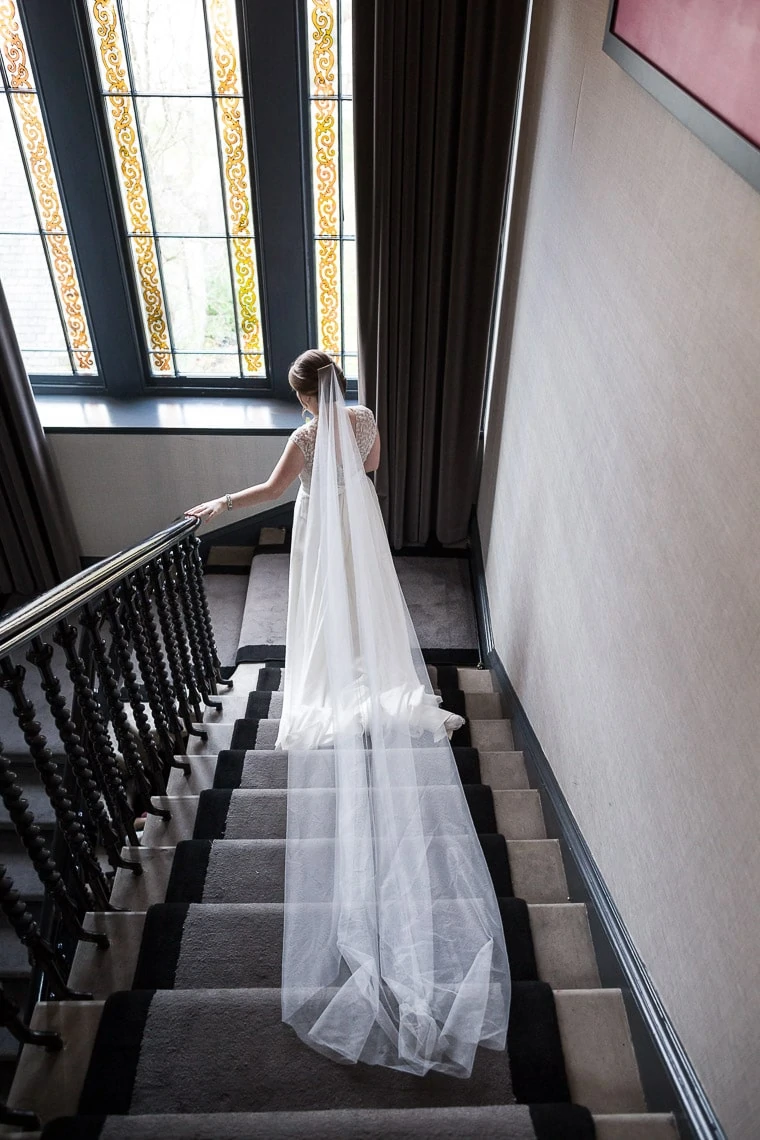 bride making her way down the staircase rear view