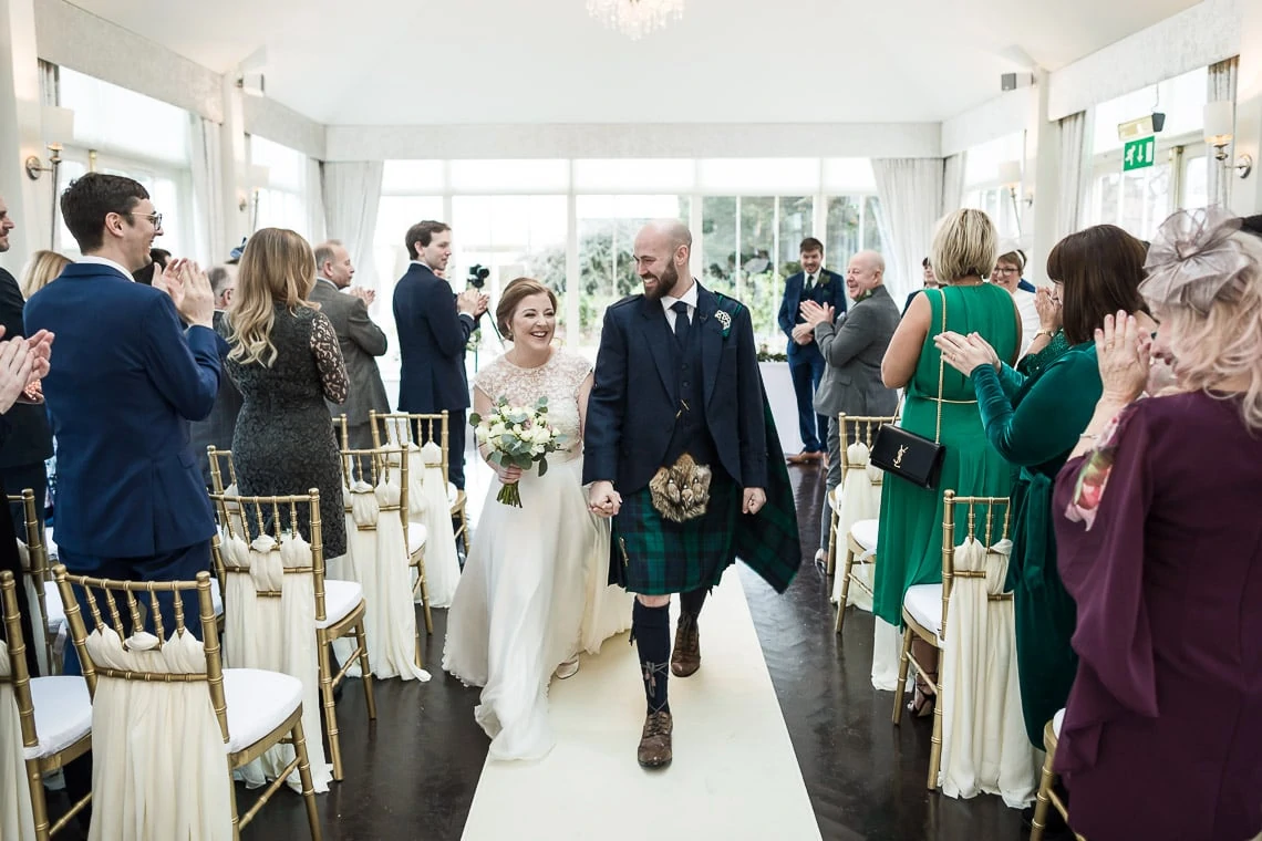 wedding recessional - newlyweds walking up the aisle of The Orangery