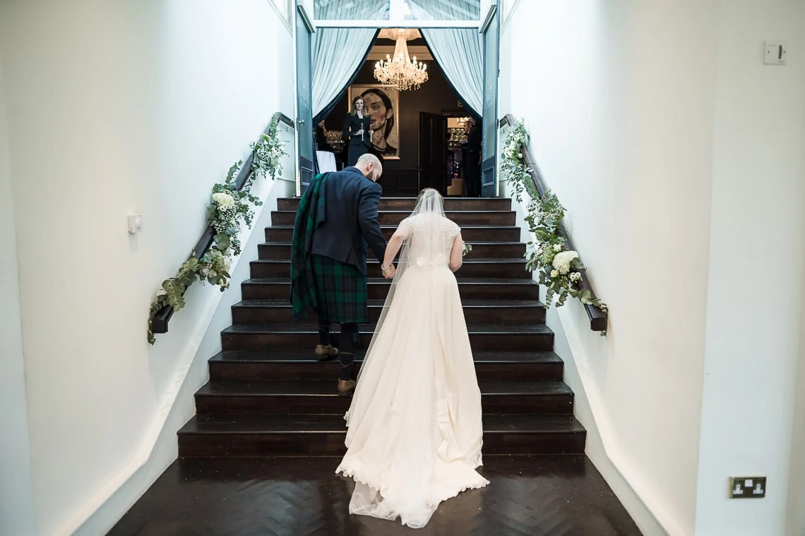 wedding recessional - newlyweds walking up the steps of The Orangery
