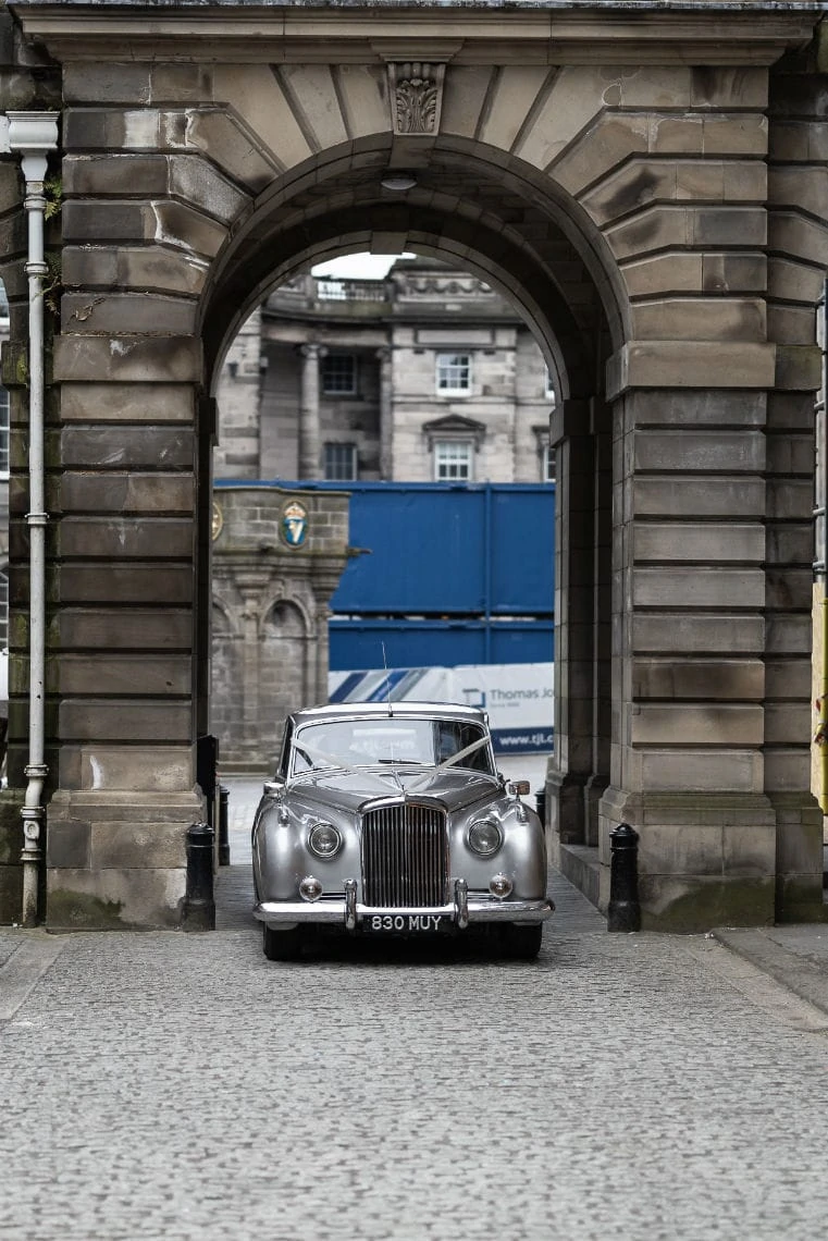 Bride and groom arriving in a classic car