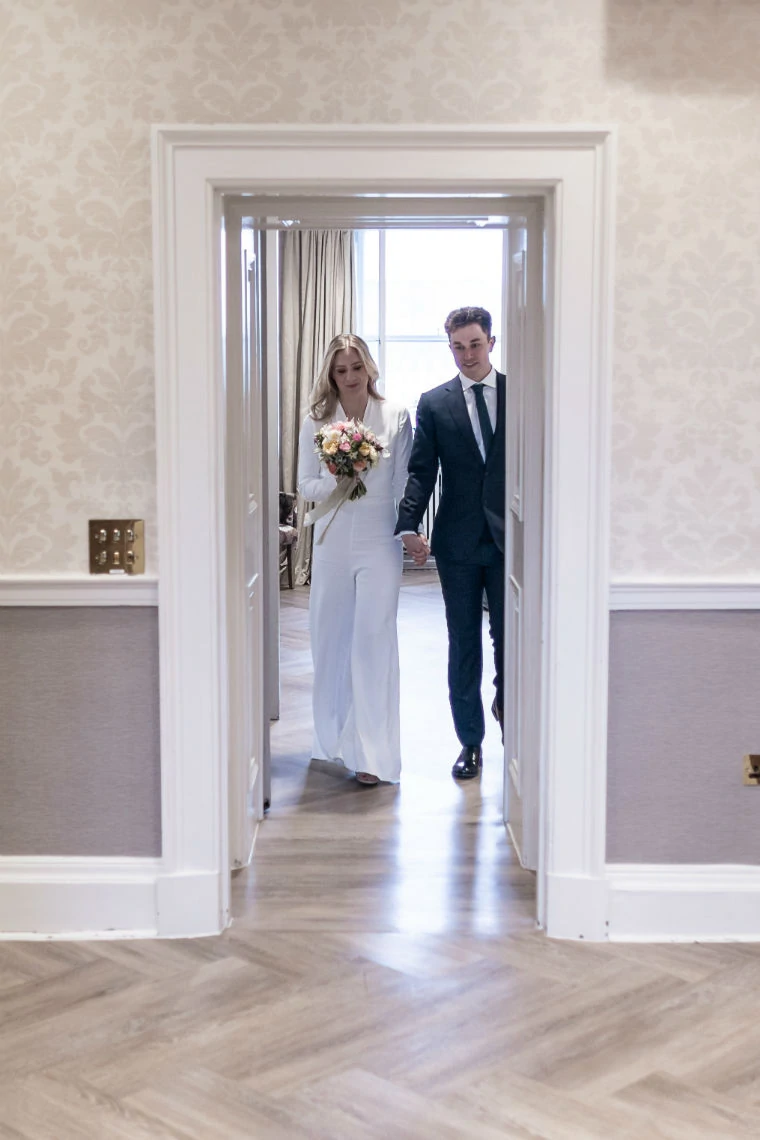 bride and groom walk into the Alexander Room