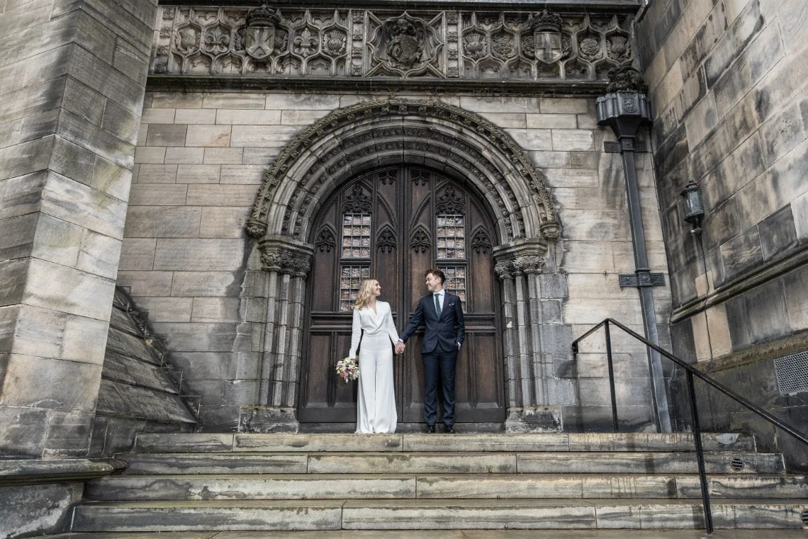 newlyweds holding hands at the back of St Giles' Cathedral