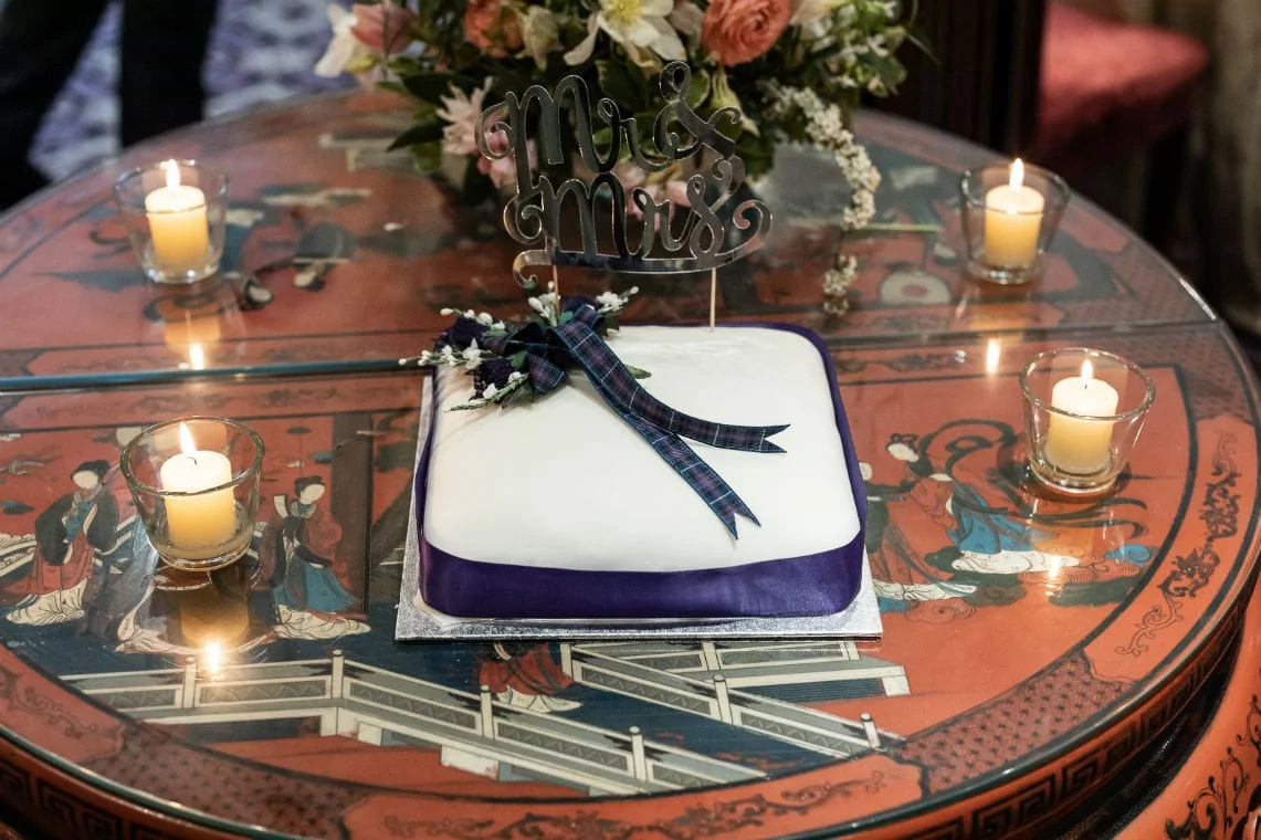 wedding cake with purple ribbon