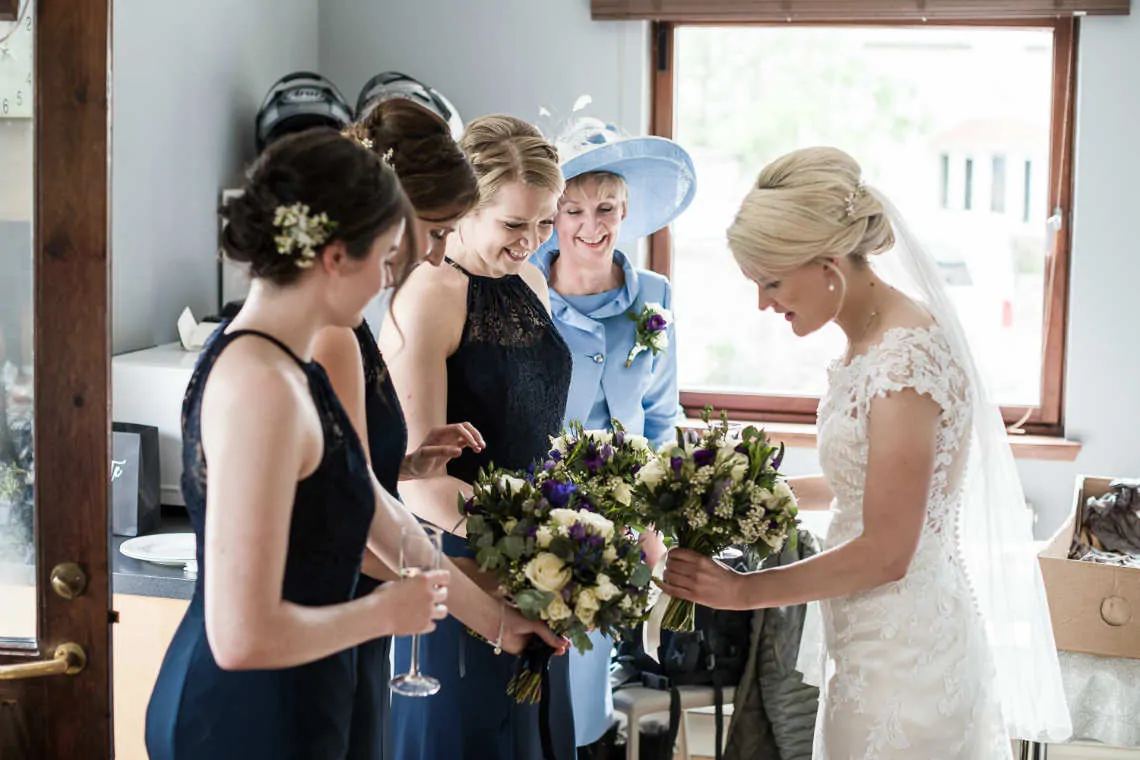Bride with bridesmaids looking at flower bouquets