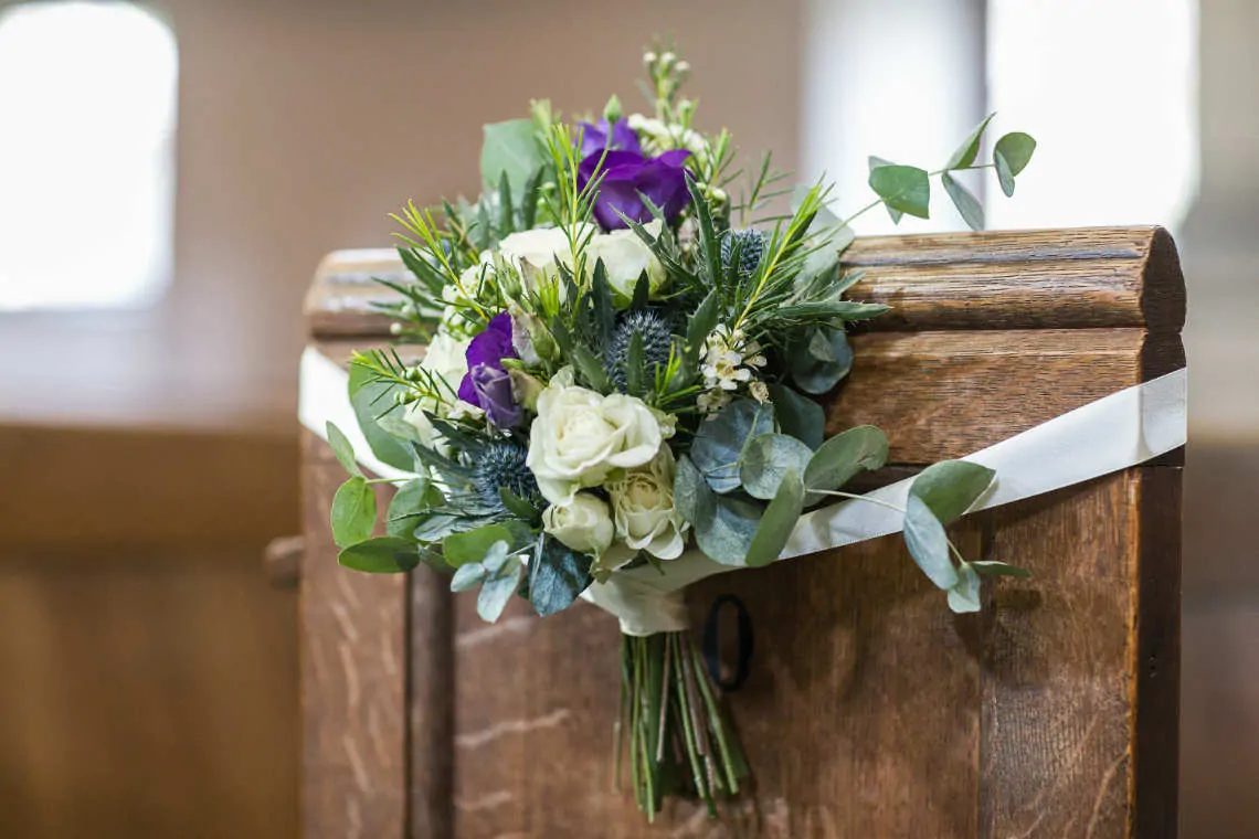Flowers tied with ribbon on church pew
