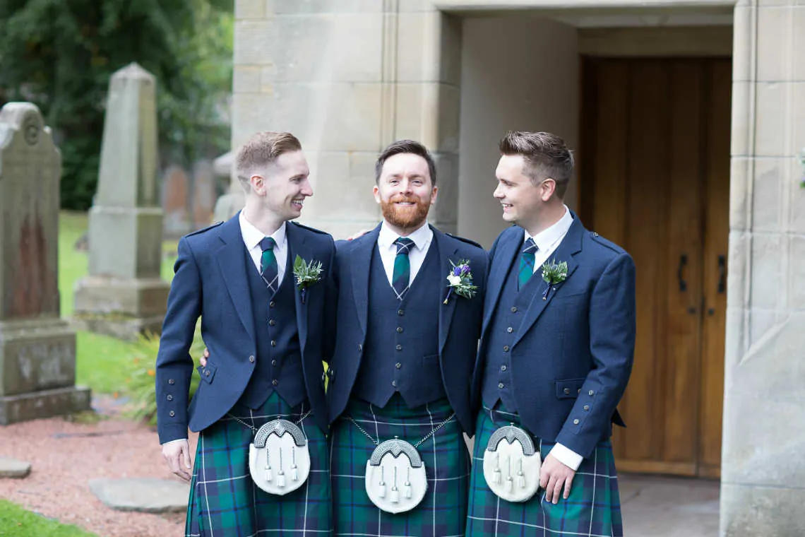 Groom with bestmen at the entrance to the church