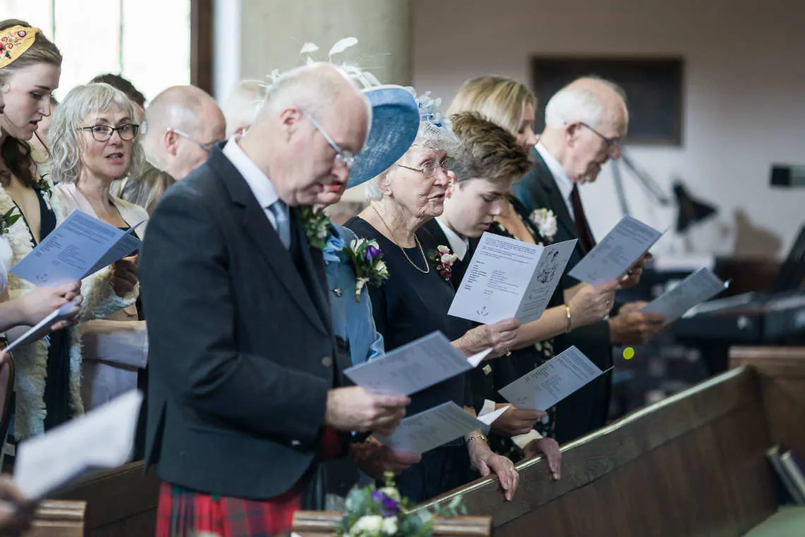 Guests singing hymns at church ceremony