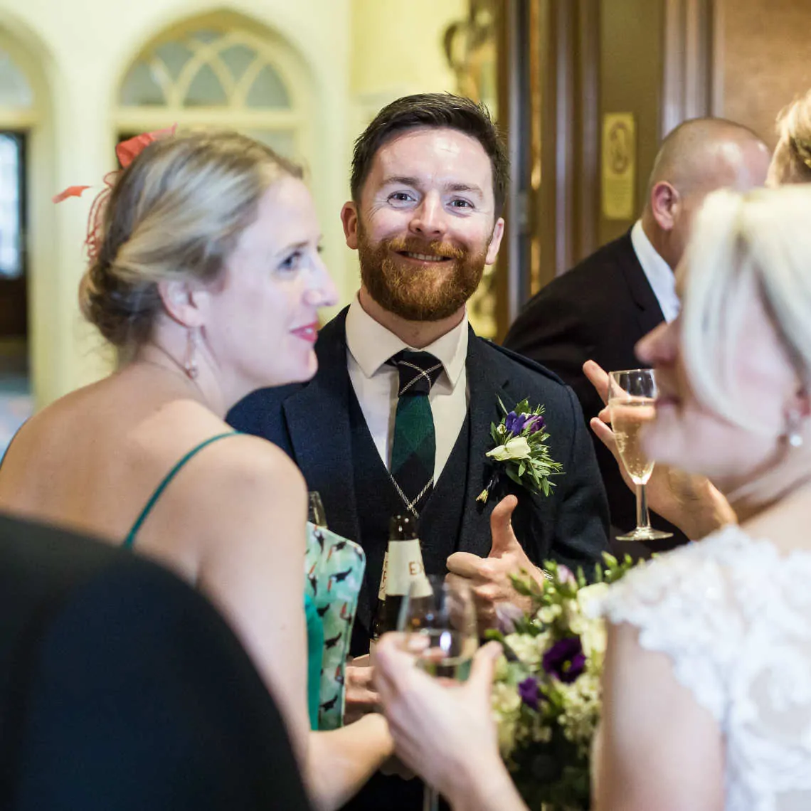 Groom smiling at the camera during drinks reception
