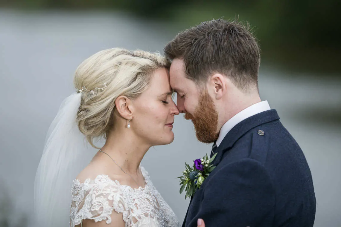 Newlyweds touching heads with their eyes closed
